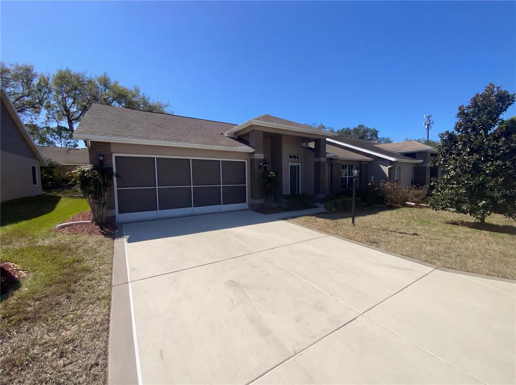 7410 Willowbrook Drive Spring Hill, FL 34606 - Photo 1 of 23 a front view of a house with a yard and garage