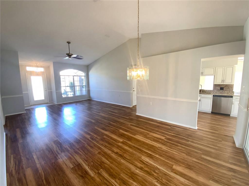 7410 Willowbrook Drive Spring Hill, FL 34606 - Photo 2 of 23 a view of an empty room with wooden floor and a kitchen