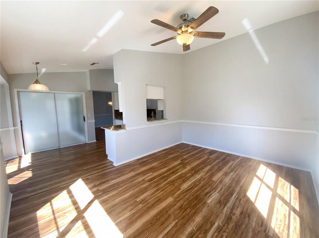7410 Willowbrook Drive Spring Hill, FL 34606 - Photo 7 of 23 a view of a room with wooden floor and a ceiling fan