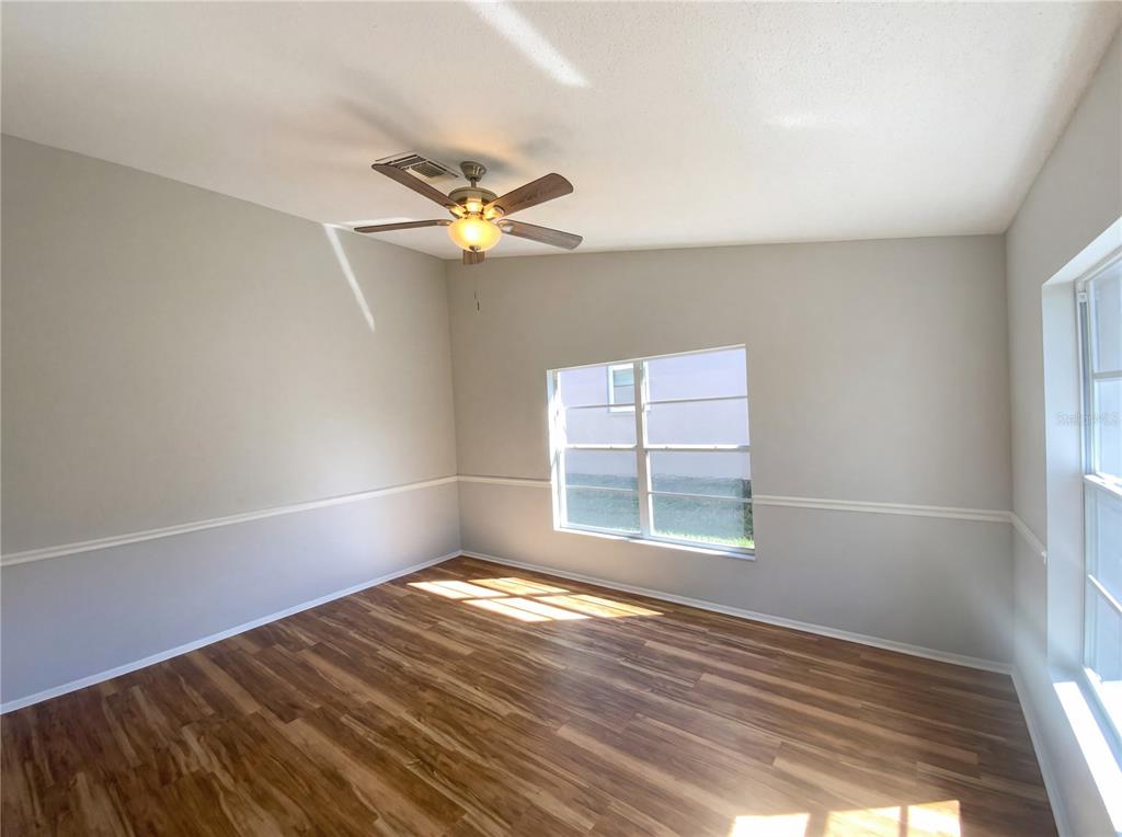 7410 Willowbrook Drive Spring Hill, FL 34606 - Photo 8 of 23 an empty room with wooden floor and windows