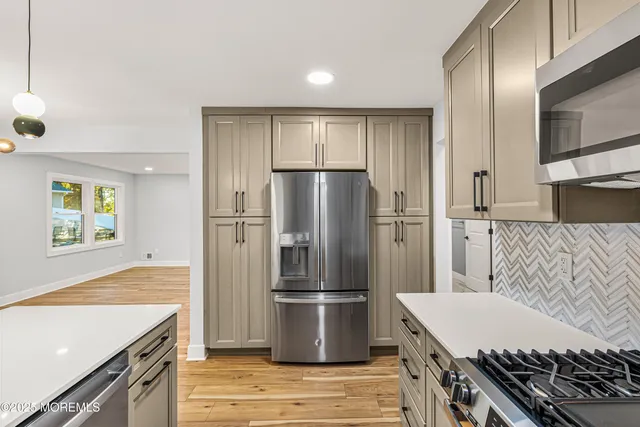 a kitchen with stainless steel appliances granite countertop a refrigerator and a stove
