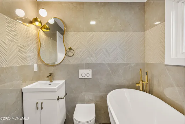 a bathroom with a sink mirror vanity and toilet