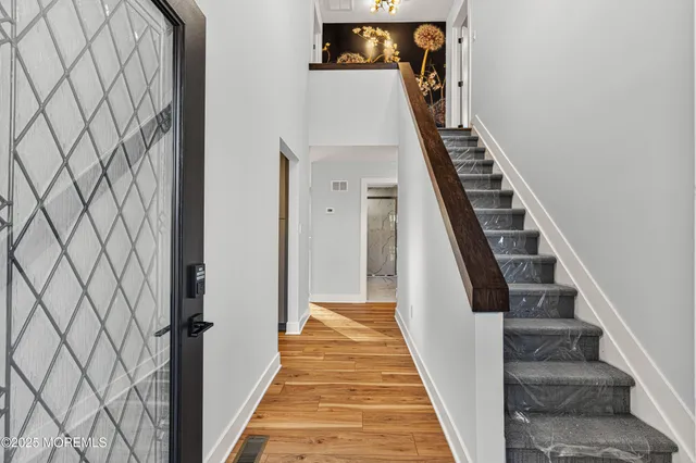 a view of a hallway with wooden floor and entryway