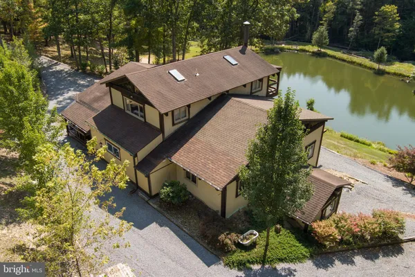 an aerial view of a house with a garden and lake view
