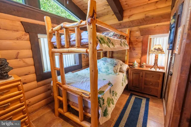 a view of a lake with a bench and trees in the background