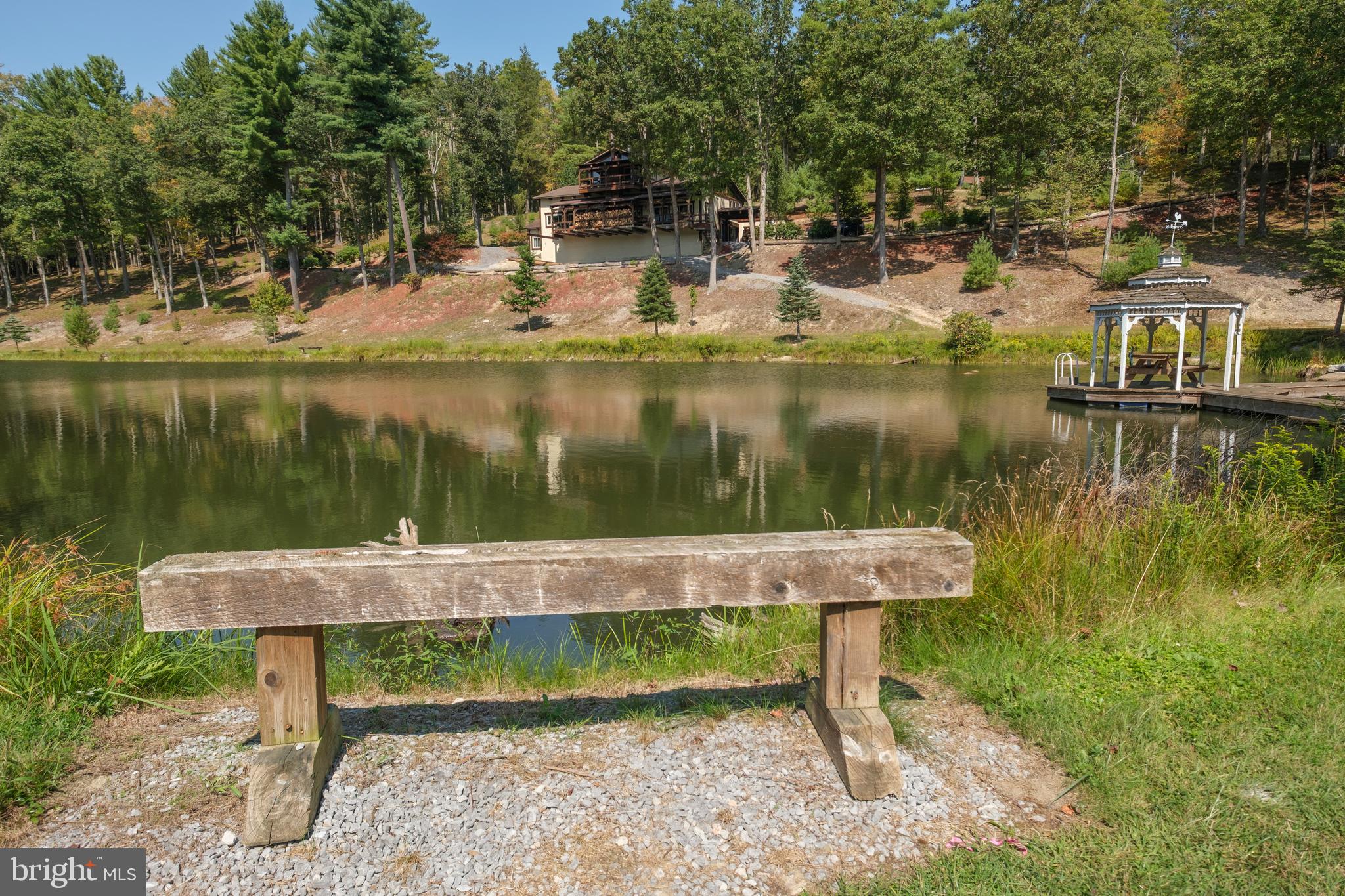 1595 Indian Springs Road Frenchville, PA 16836 - Photo 66 of 86 a view of a lake with a bench and trees in the background