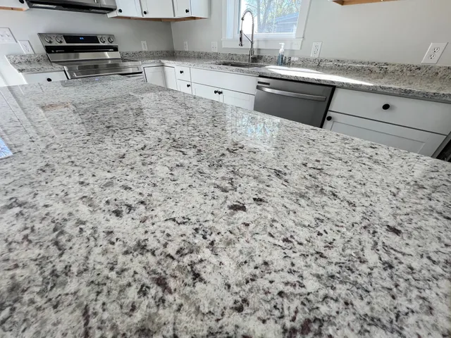 a kitchen with stainless steel appliances granite countertop a sink stove and granite counter top