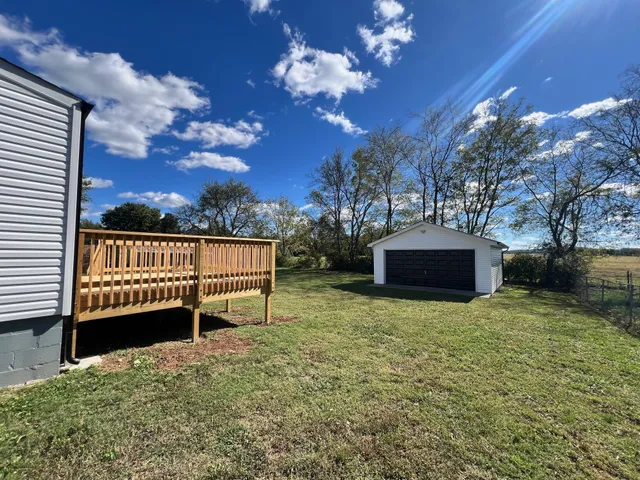a view of a house with backyard and sitting area