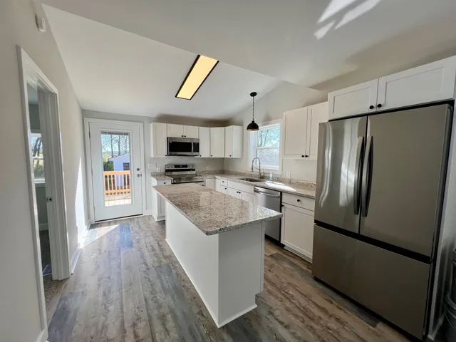 a kitchen with stainless steel appliances granite countertop a refrigerator stove and oven