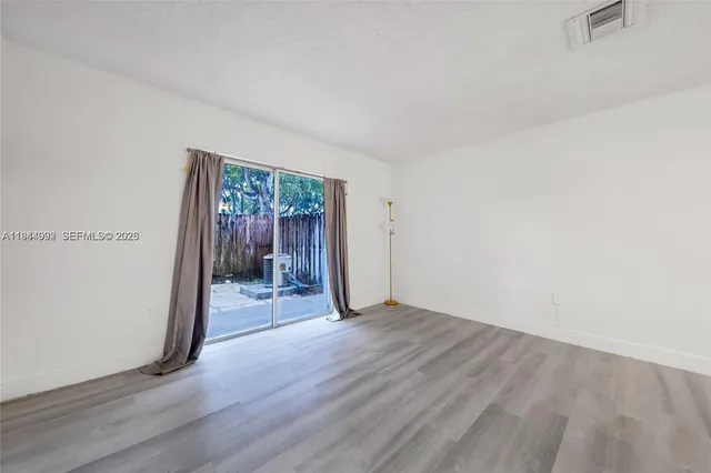 an empty room with wooden floor and a window
