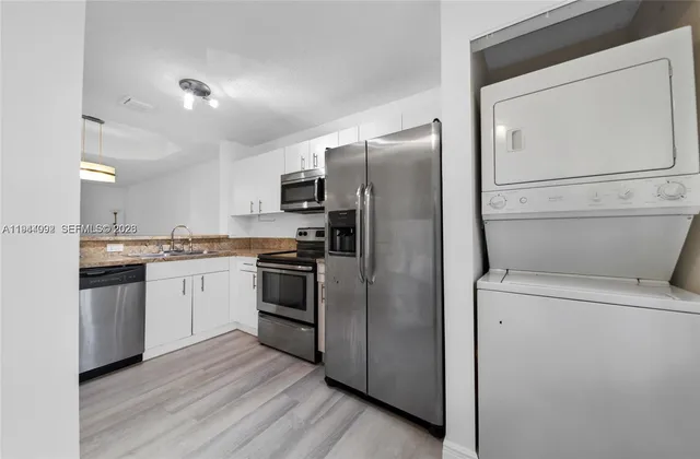 a kitchen with a refrigerator sink and cabinets