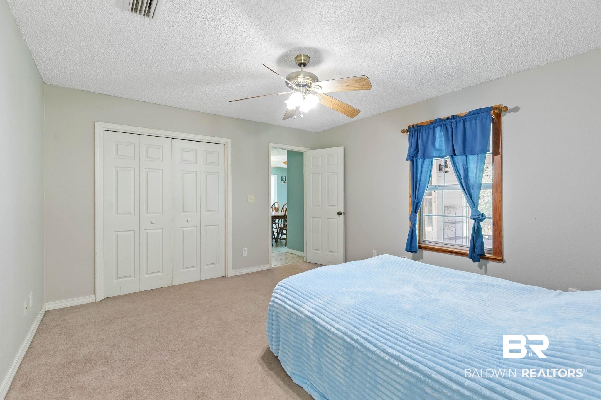 20219 Greek Cemetery Road Robertsdale, AL 36567 - Photo 29 of 41 Neutral wall color throughout, featuring a ceiling fan with light fixture, carpeted flooring, and a window with wood trim