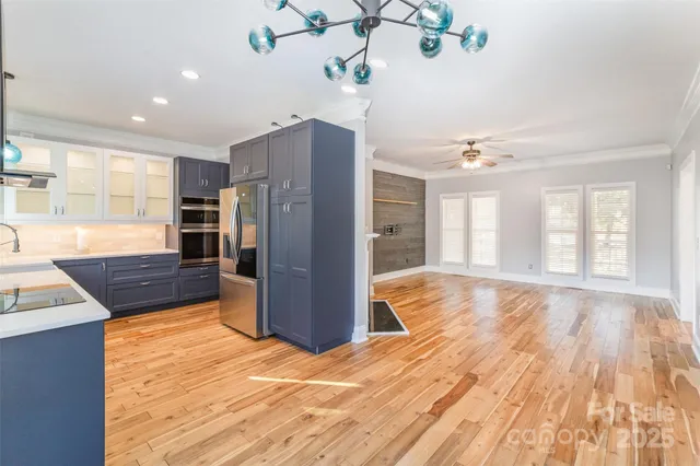 a view of a kitchen with wooden floor and refrigerator
