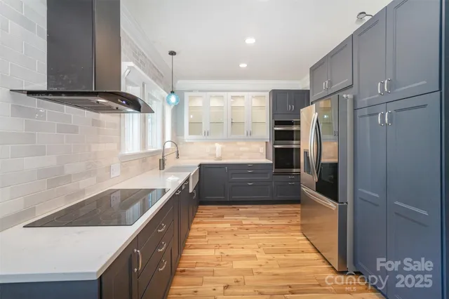 a large kitchen with kitchen island granite countertop a refrigerator and a sink