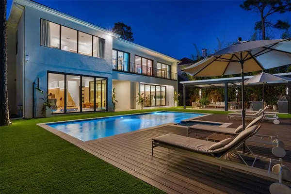 a view of swimming pool with chairs and umbrella