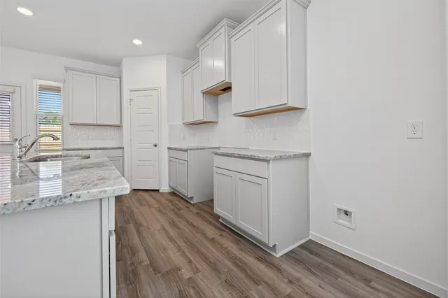 a kitchen with a sink and wooden floor