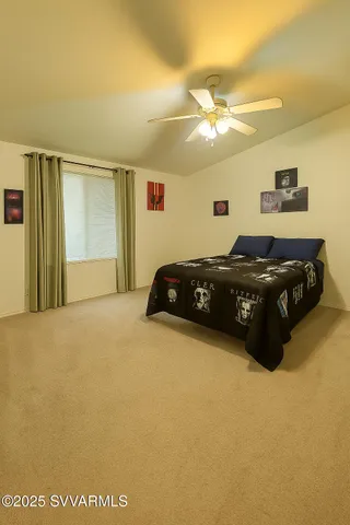 a bedroom with a bed and a ceiling fan