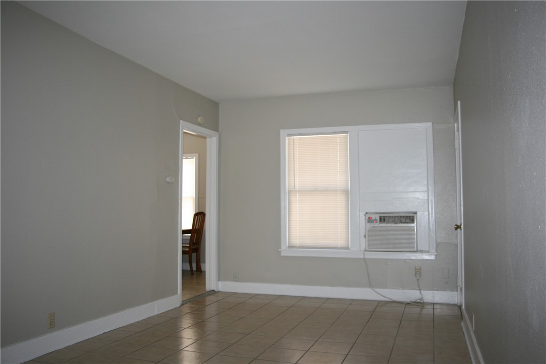 814 Ohio Avenue, Unit 2 Corpus Christi, TX 78404 - Photo 3 of 9 an empty room with wooden floor and windows
