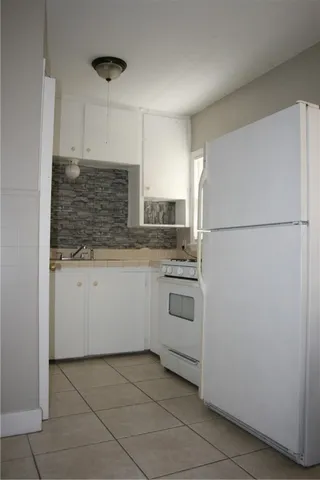 a kitchen with white cabinets and white appliances