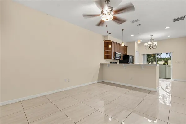 a view of kitchen with kitchen island stainless steel appliances refrigerator cabinets and microwave
