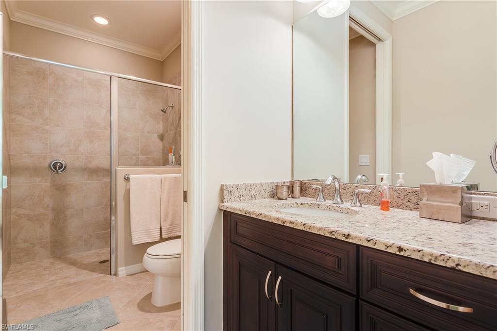9082 Capistrano Street North, Unit 485 Naples, FL 34113 - Photo 11 of 16 a bathroom with a granite countertop sink toilet and shower