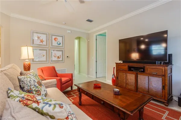 a living room with furniture a flat screen tv and a window