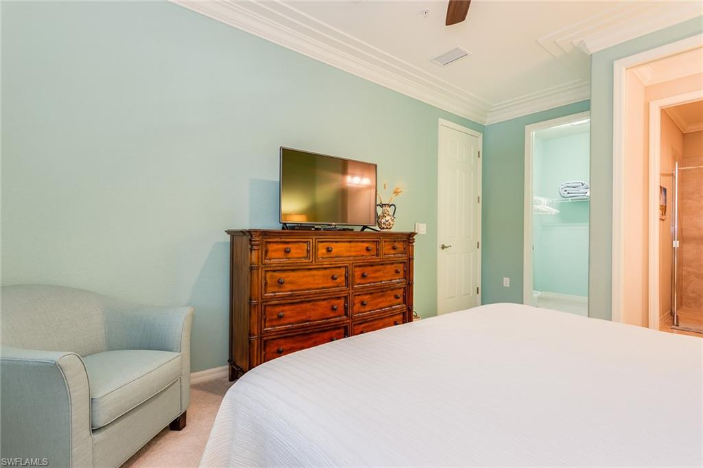 9082 Capistrano Street North, Unit 485 Naples, FL 34113 - Photo 9 of 16 a bedroom with a bed and a flat screen tv