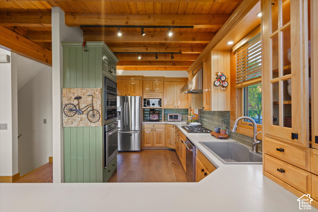 5878 Snowbasin Road Huntsville, UT 84317 - Photo 20 of 90 Exposed wood beam ceiling, wood-finish flooring, built-in stainless steel appliances, light wood cabinetry with glass-front uppers, and a tile backsplash