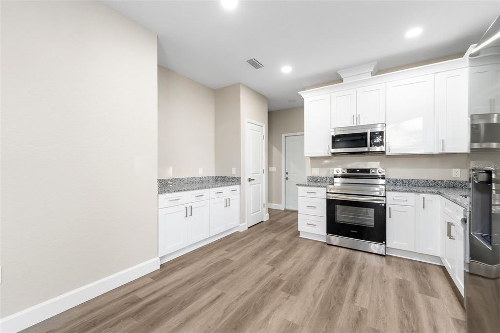2016 Northeast 3rd Avenue Gainesville, FL 32641 - Photo 13 of 35 a kitchen with granite countertop white cabinets and stainless steel appliances
