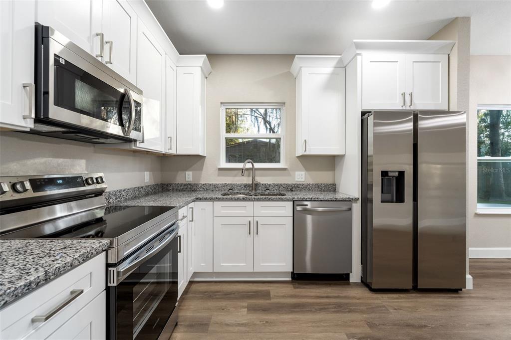 2016 Northeast 3rd Avenue Gainesville, FL 32641 - Photo 14 of 35 a kitchen with stainless steel appliances granite countertop a refrigerator stove and microwave