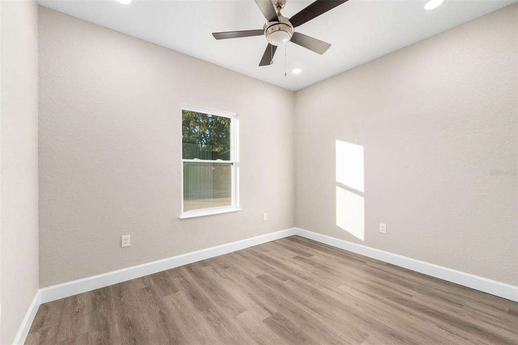 2016 Northeast 3rd Avenue Gainesville, FL 32641 - Photo 20 of 35 an empty room with wooden floor fan and windows