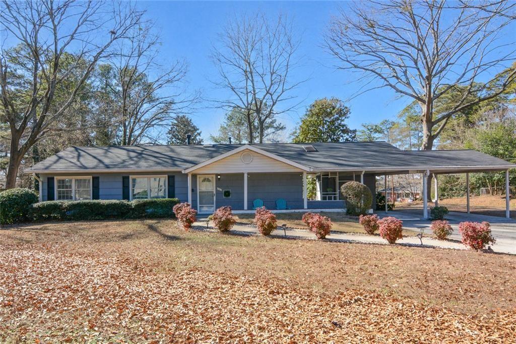 a view of a house with a yard covered in the forest