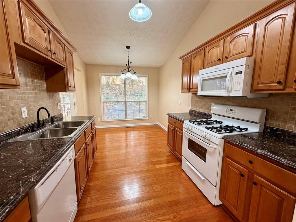 604 Victorian Circle Dallas, GA 30157 - Photo 6 of 25 a kitchen with granite countertop a sink stove and cabinets