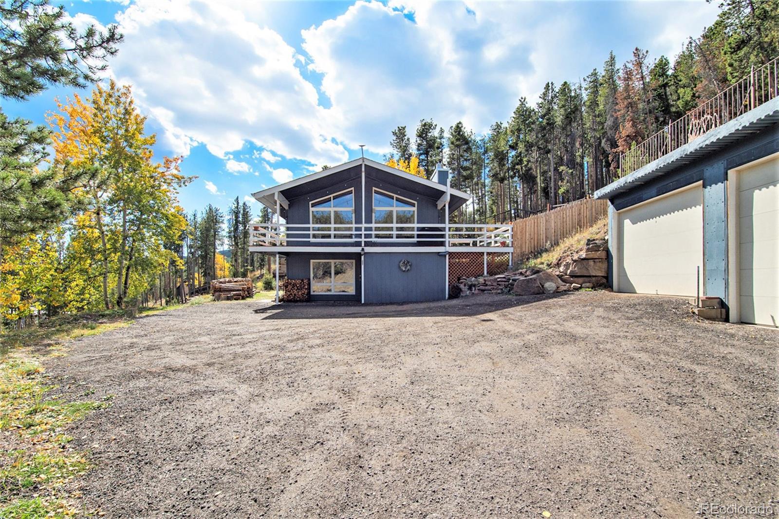 779 Aspen Way Evergreen, CO 80439 - Photo 27 of 49 a big house with large trees and wooden fence