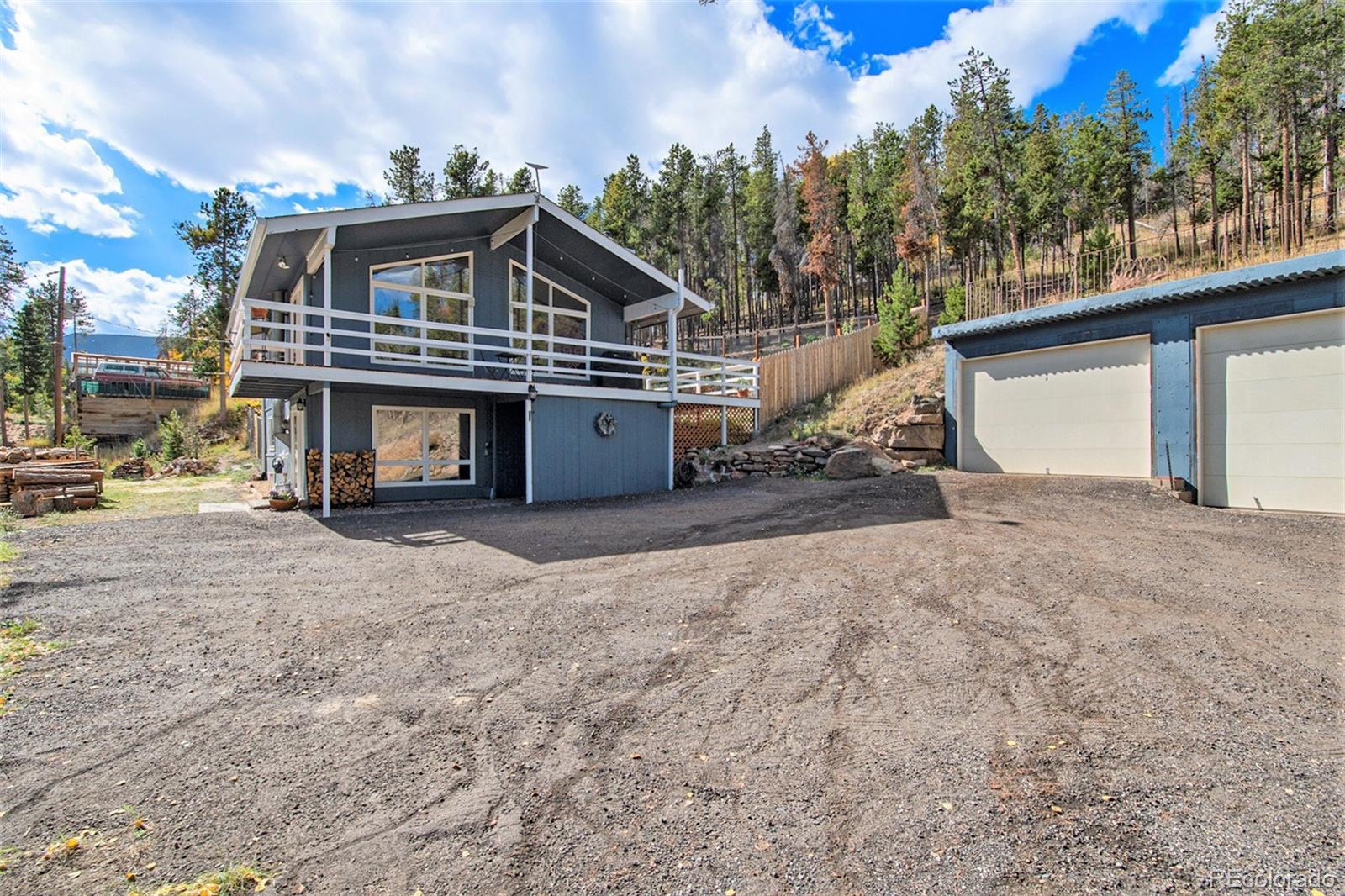 779 Aspen Way Evergreen, CO 80439 - Photo 32 of 49 a front view of a house with a yard and garage