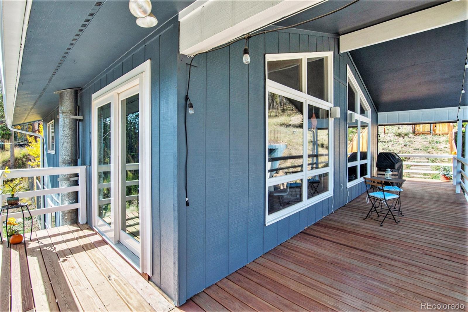 779 Aspen Way Evergreen, CO 80439 - Photo 35 of 49 a view of a balcony with chairs and wooden floor