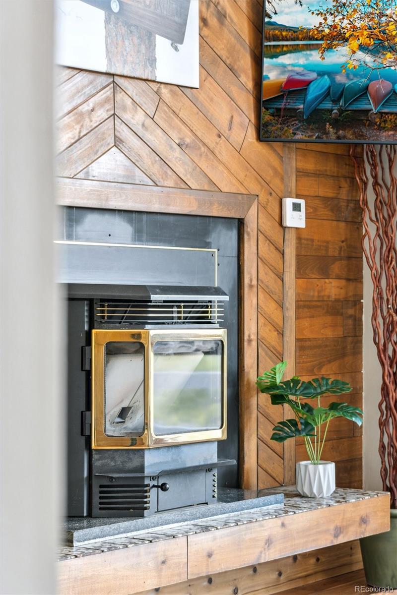779 Aspen Way Evergreen, CO 80439 - Photo 6 of 49 a living room with a fireplace and wooden floor