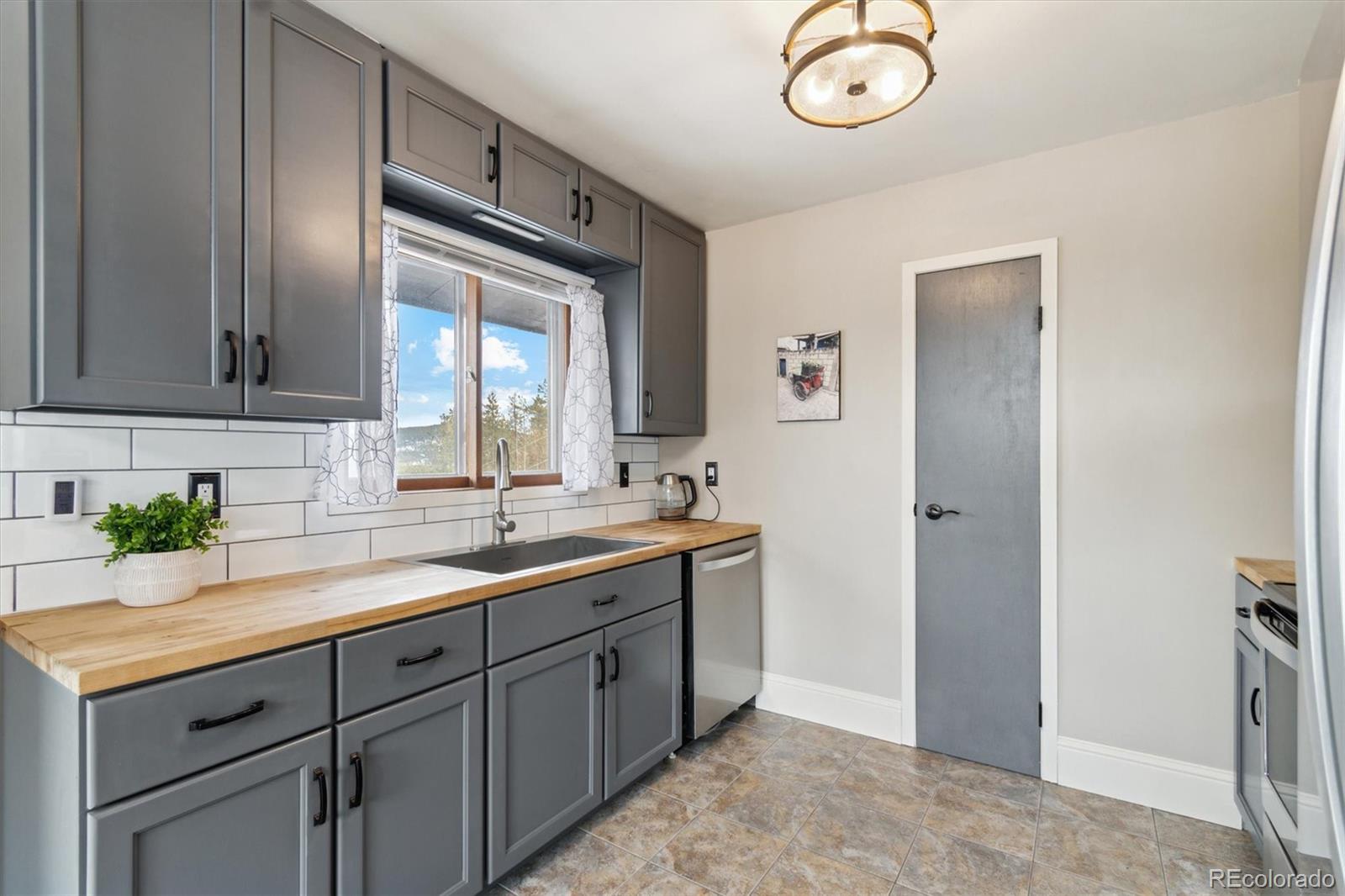 779 Aspen Way Evergreen, CO 80439 - Photo 10 of 49 a kitchen with a sink and a refrigerator