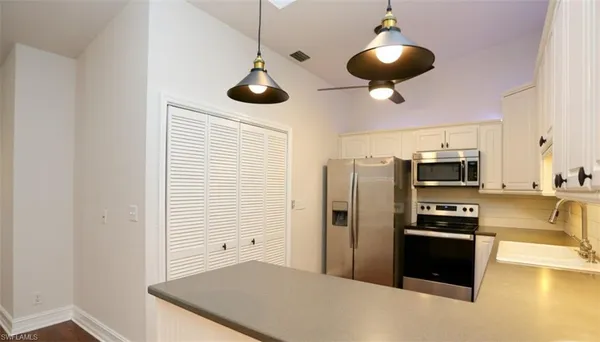 a kitchen with stainless steel appliances kitchen island granite countertop a stove and a refrigerator