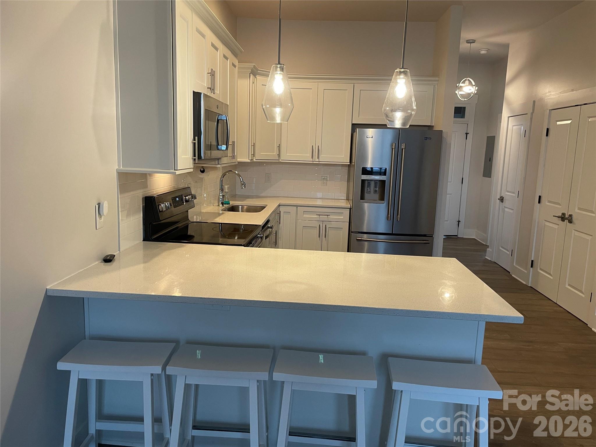 a large kitchen with a table chairs refrigerator and microwave