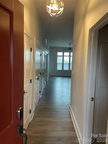 a view of a hallway with wooden floor and stairs