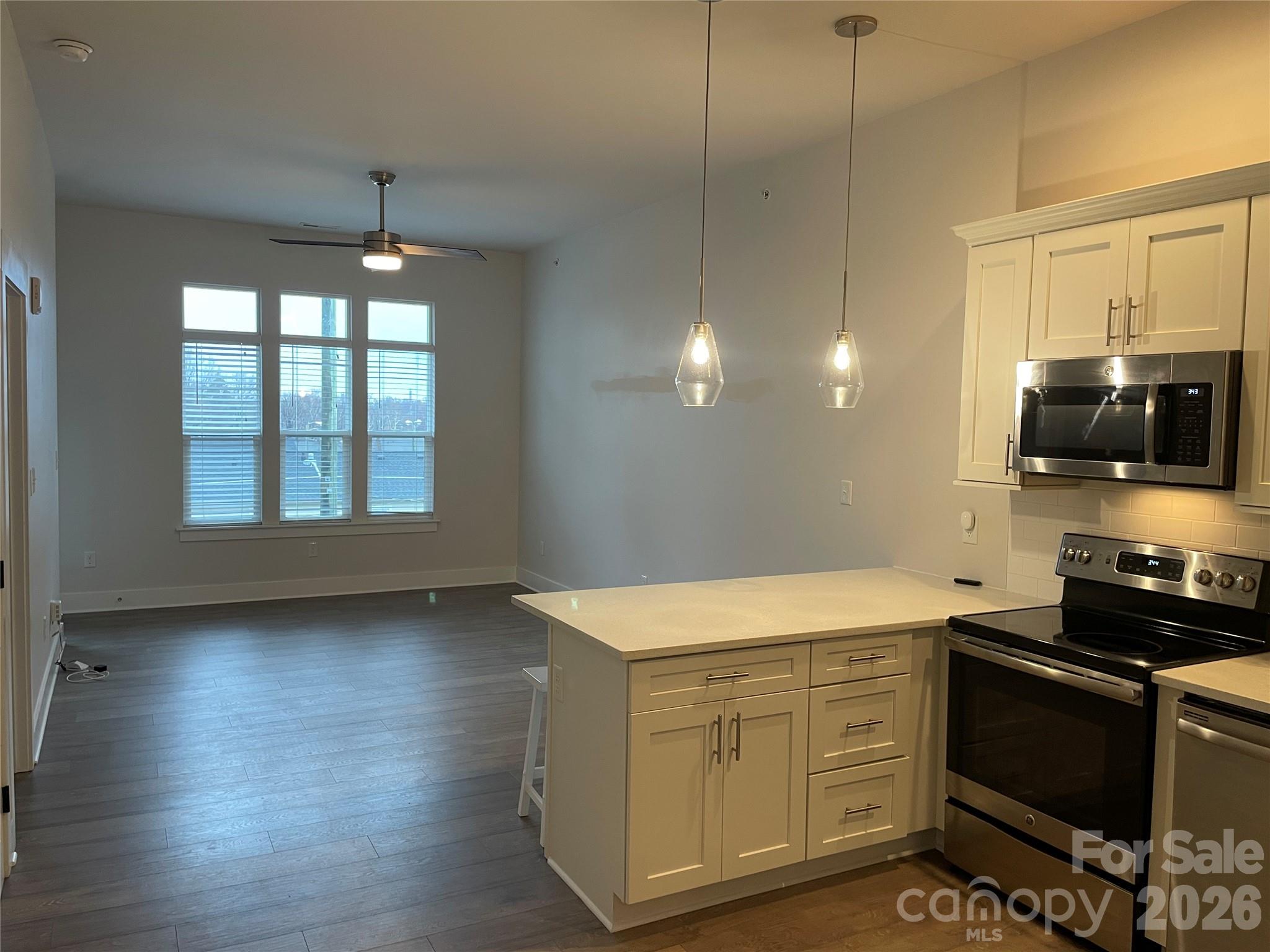 935 McAlway Road, Unit 303 Charlotte, NC 28211 - Photo 4 of 16 a kitchen with a wooden floor and a stove top oven