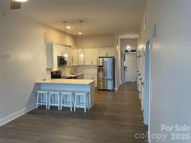a kitchen with kitchen island a sink cabinets and stainless steel appliances