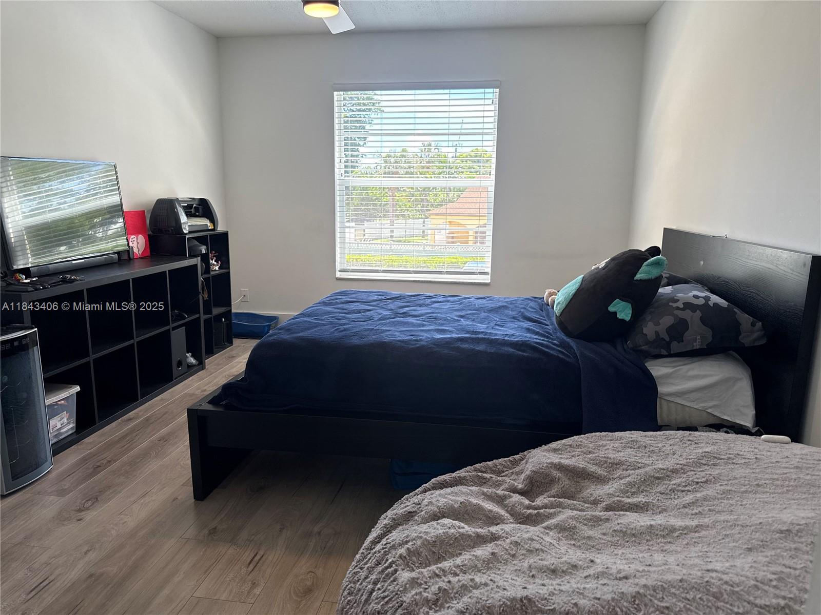 480 Northwest 20th Street, Unit 207 Boca Raton, FL 33431 - Photo 12 of 26 a bedroom with a bed and wooden floor