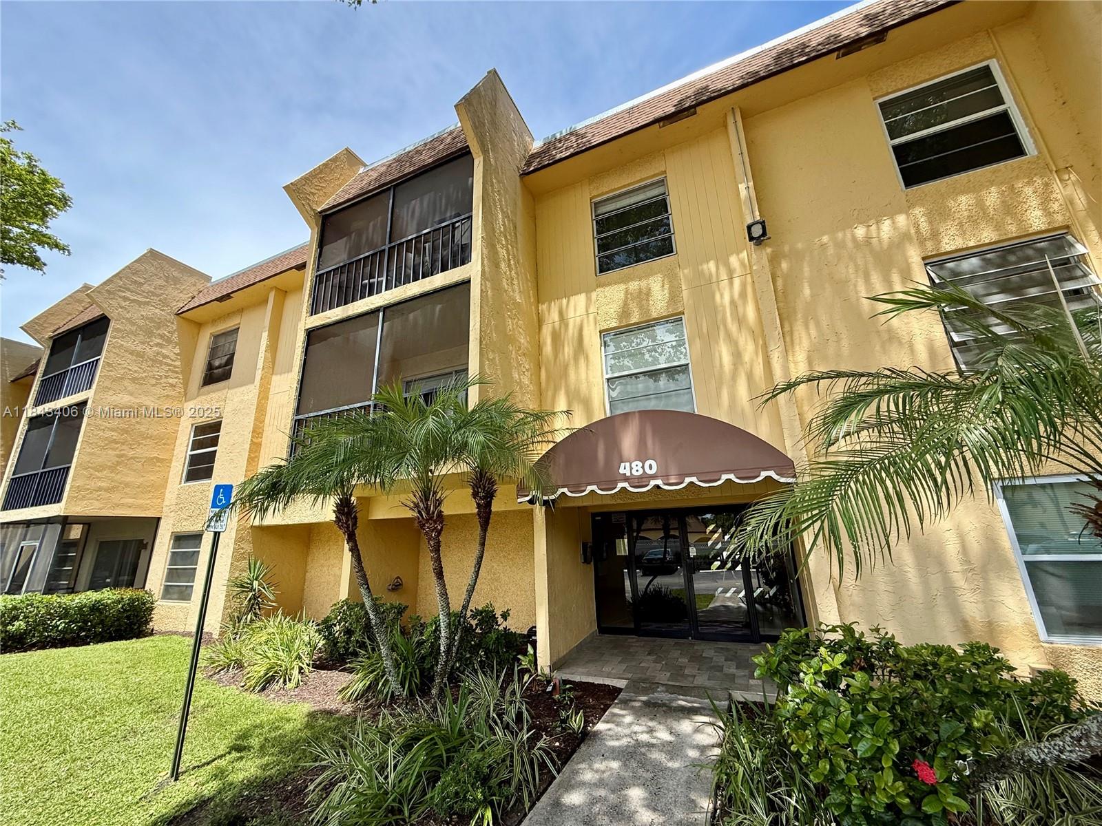 480 Northwest 20th Street, Unit 207 Boca Raton, FL 33431 - Photo 17 of 26 a front view of a house with a yard