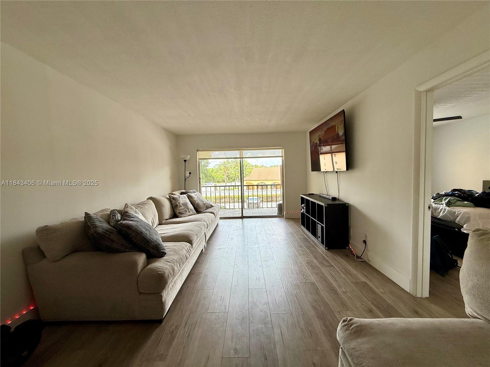 480 Northwest 20th Street, Unit 207 Boca Raton, FL 33431 - Photo 2 of 26 a living room with furniture and a flat screen tv