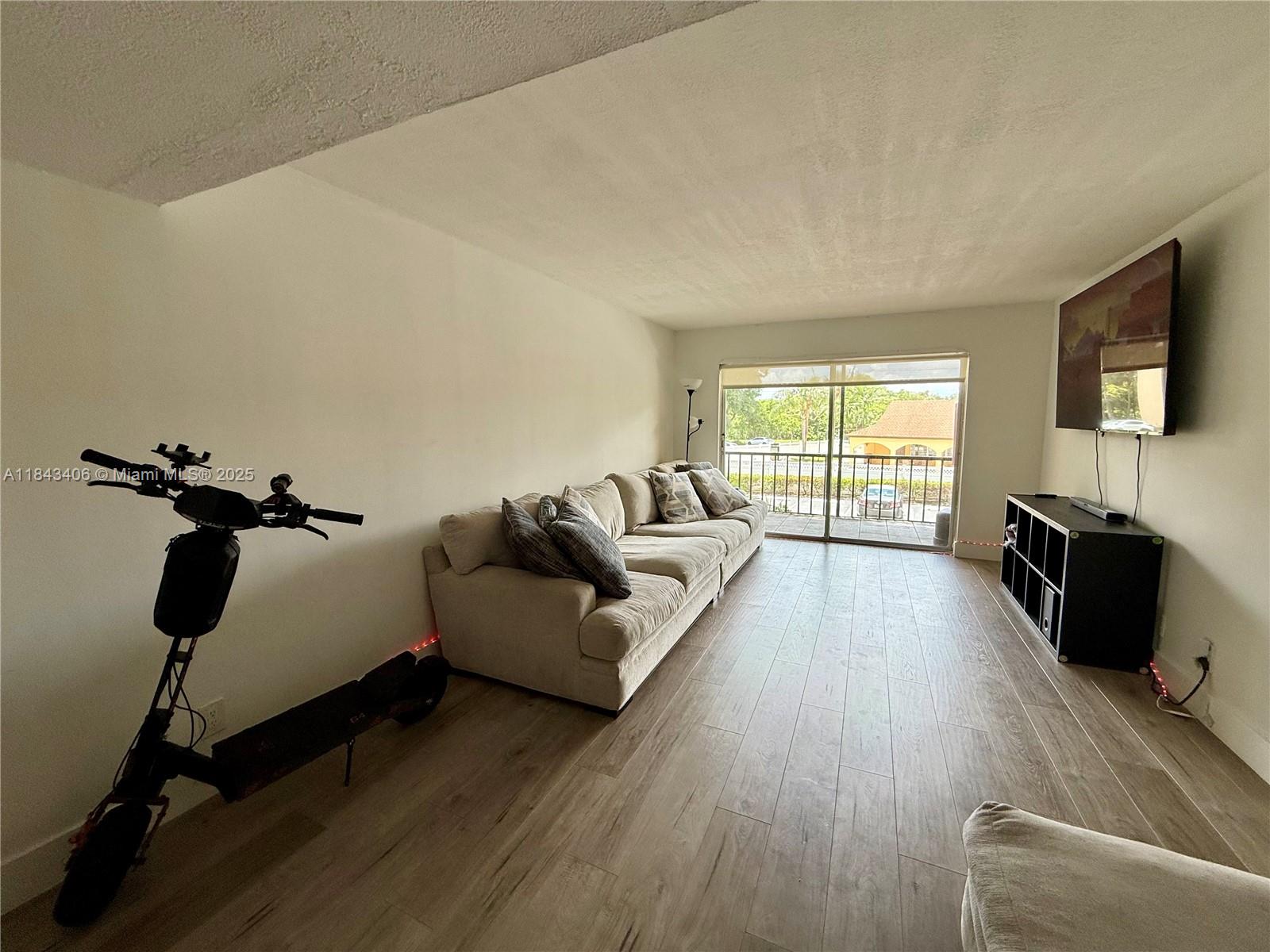 480 Northwest 20th Street, Unit 207 Boca Raton, FL 33431 - Photo 5 of 26 a living room with furniture and a flat screen tv