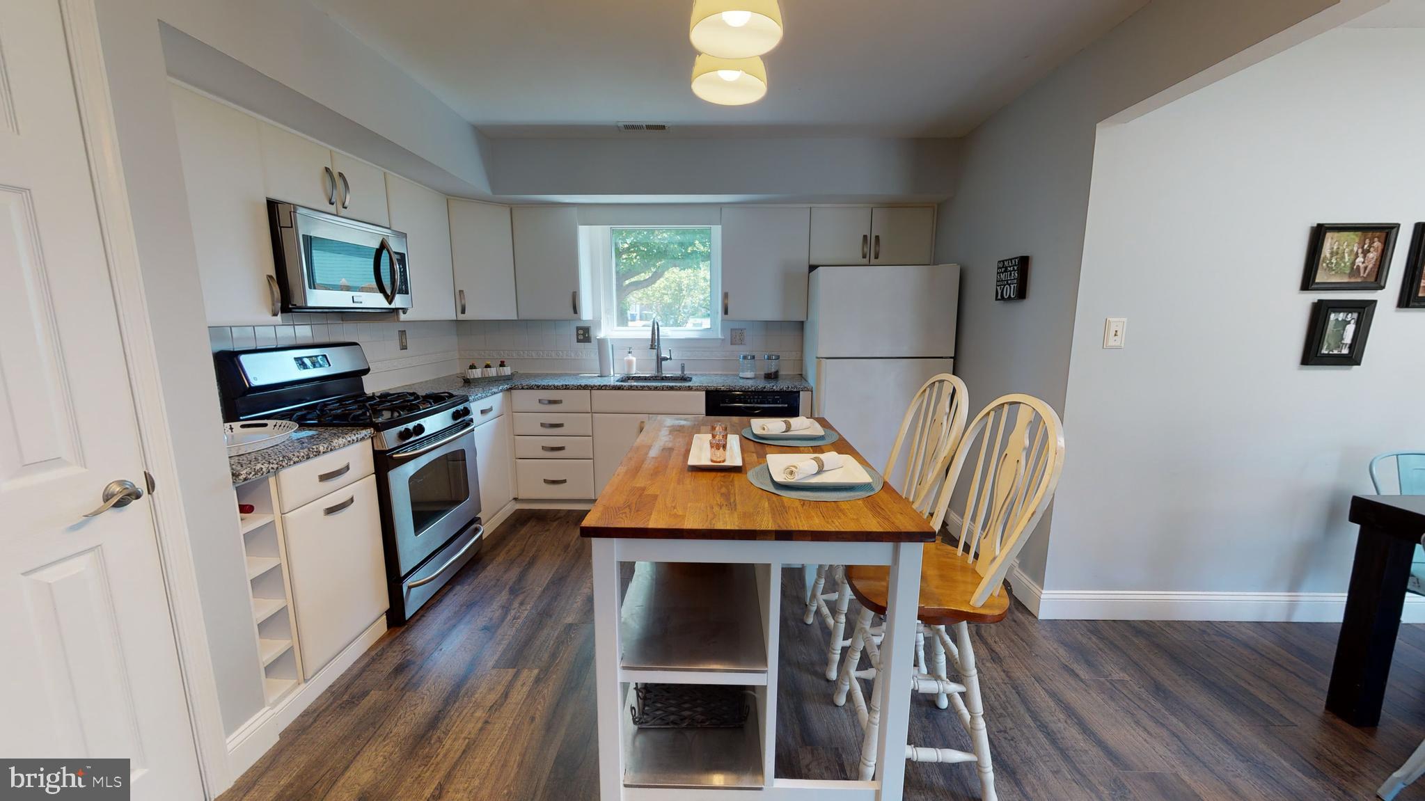 5 Carlton Avenue Evesham, NJ 08053 - Photo 7 of 33 a kitchen with a stove a refrigerator a sink a dining table and chairs