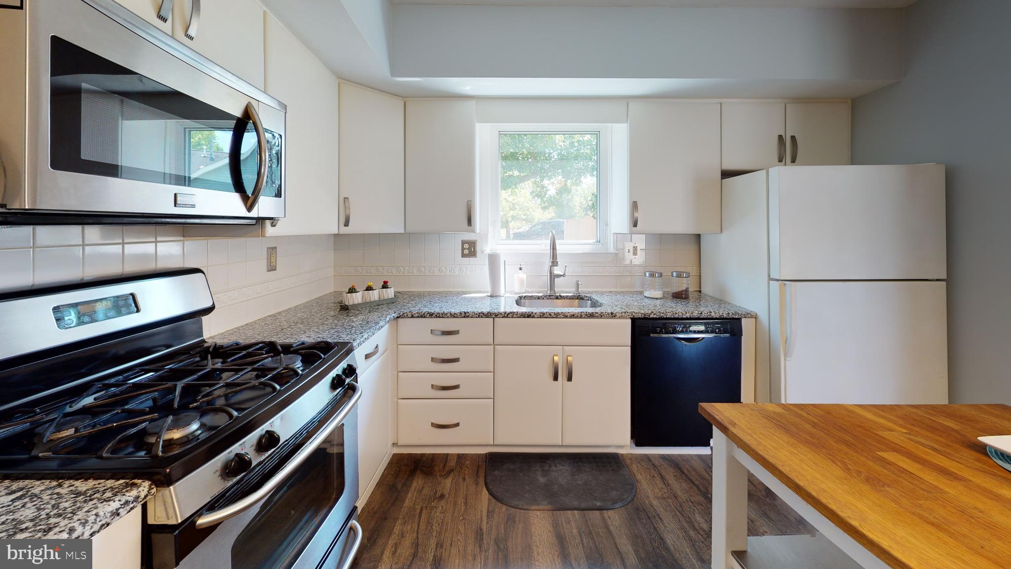 5 Carlton Avenue Evesham, NJ 08053 - Photo 8 of 33 a kitchen with wooden cabinets and white appliances
