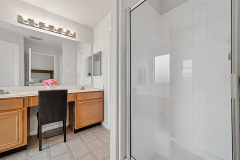 a bathroom with a double vanity sink mirror and bathtub